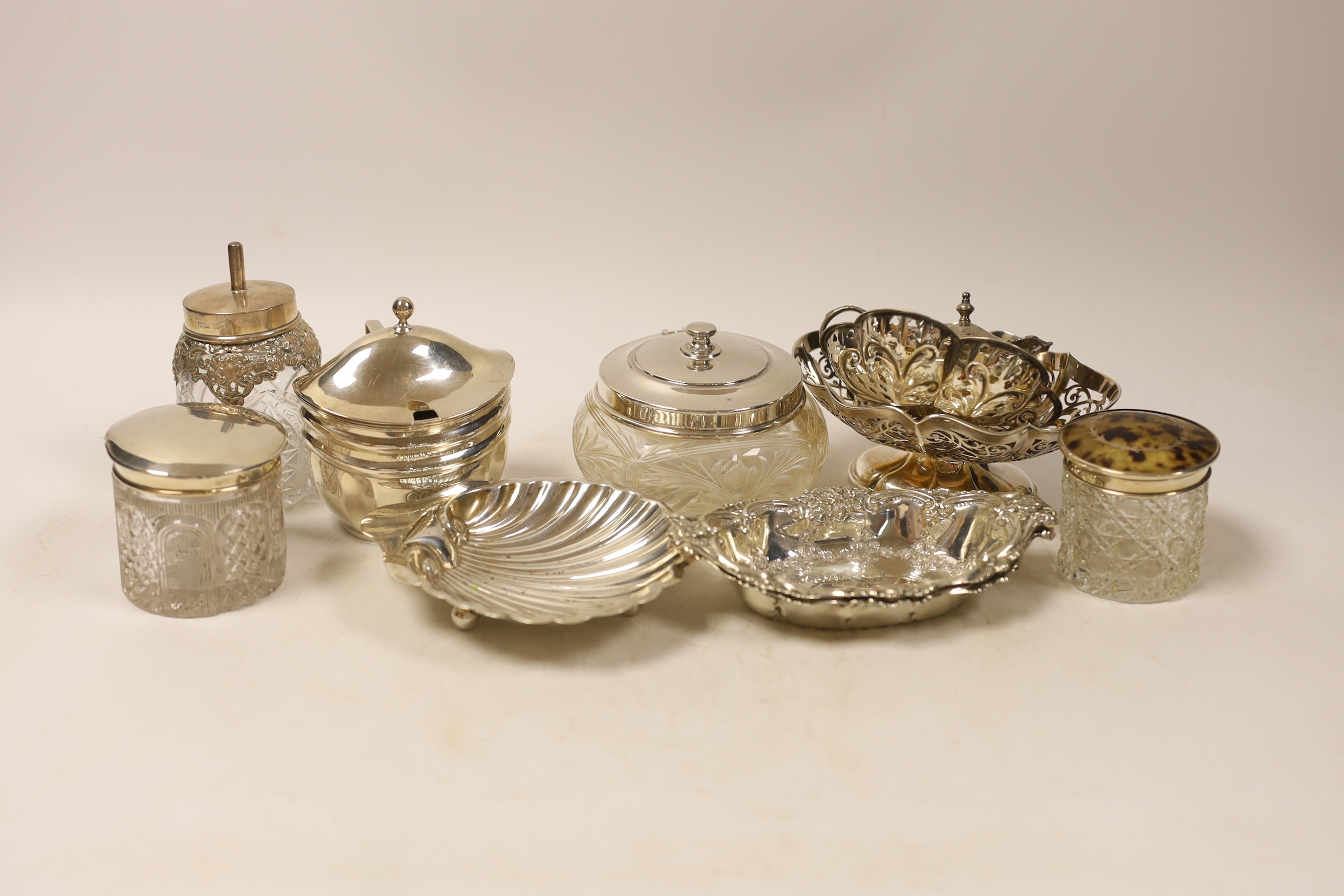 A group of silverware including a pair of bonbon dishes, butter shell, pierced dishes, toilet jars and a George III mustard, London, 1806, etc.